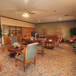 A cozy lounge area with wooden furniture and decorative plants.