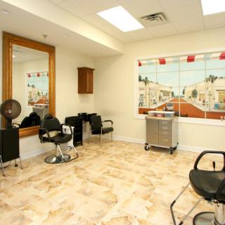 A well-lit hair salon interior with styling chairs, a large mirror, and decorative wall art.