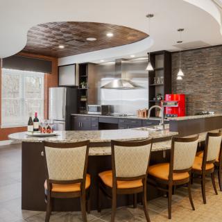 A modern kitchen with a bar-style countertop and stylish seating.