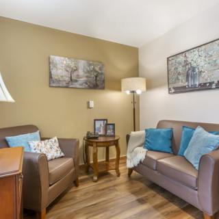 A cozy living room with a sofa, armchair, and decorative elements.