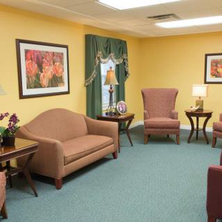 A well-furnished living room with sofas, armchairs, tables, and lamps.