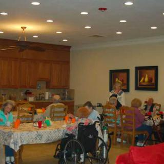 Residents of a care facility gather in the dining area.