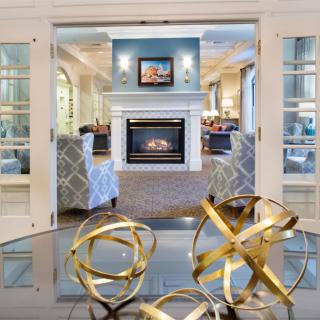 A modern living room with a fireplace and geometric sculptures in the foreground.