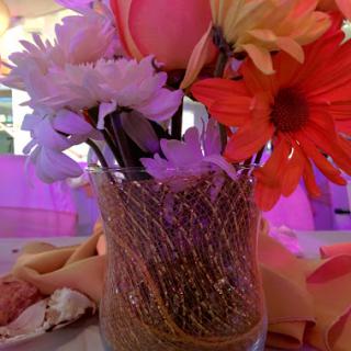 A vibrant floral arrangement in a decorative vase, perfect for adding a touch of elegance to any event.