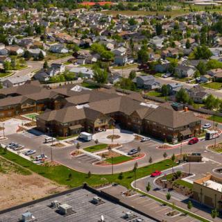Aerial view of a suburban neighborhood with a central building and parking lot.