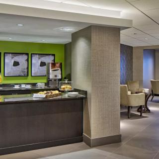Modern hotel lobby with a reception area and comfortable seating.
