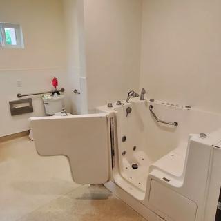 An accessible bathroom featuring a walk-in bathtub designed for elderly or disabled individuals.