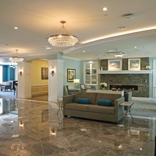 A modern lobby with a chandelier, marble flooring, and elegant furniture.