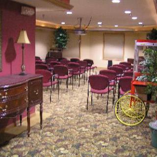 An empty conference room set up with rows of chairs and a projector.