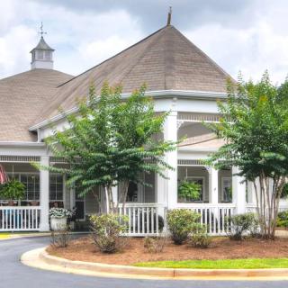 A picturesque gazebo surrounded by trees and a well-maintained garden.