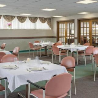 An indoor dining room with multiple tables and chairs, set up with tableware.