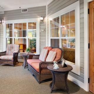A cozy seating area with patio furniture and large windows, perfect for relaxation.
