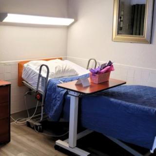 A neatly arranged hospital room with a bed and medical equipment.