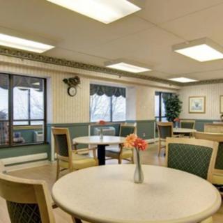 A cozy dining area with tables and chairs, adorned with a vase of flowers and decorative elements.