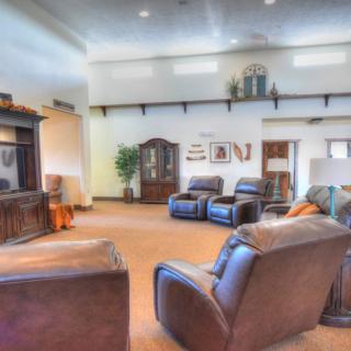 A cozy living room with leather chairs, a television, and various decorative elements.