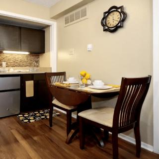 A cozy dining area with a wooden table and chairs adjacent to a modern kitchen.