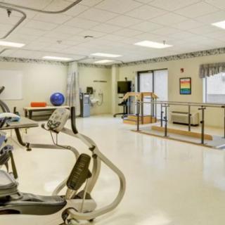 A rehabilitation and therapy room equipped with exercise machines and physical therapy tools.