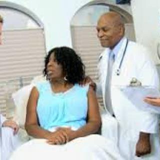 A medical team consulting with a patient in a hospital setting.