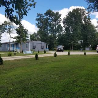 A scenic view of a house surrounded by trees and a grassy area.
