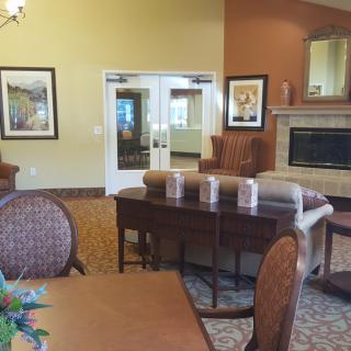 A cozy living room featuring comfortable chairs, a sofa, a fireplace, and artwork on the walls.