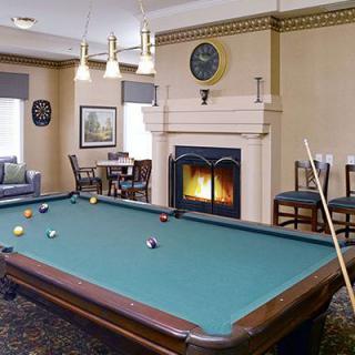 A cozy living room with a pool table and a fireplace.