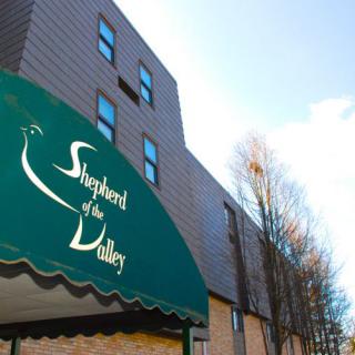 A building with an awning displaying the name 'Shepherd of the Valley'.