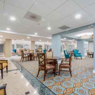 A spacious hotel lobby with elegant seating and bright lighting.