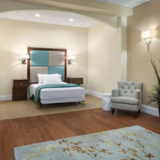 A well-furnished bedroom with a bed, armchair, and stylish decor.