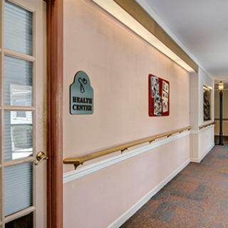 A hallway with a door labeled 'Health Center', featuring wall decor and handrails.