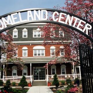 Entrance to the Land Center with a charming architectural design and blooming surroundings.