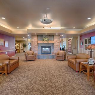 A cozy lobby with comfortable seating and a central fireplace.