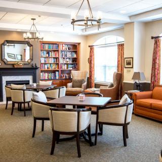 A cozy living room with comfortable seating and a library area.