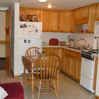 Cozy kitchen with wooden cabinets, a dining table, and essential appliances.