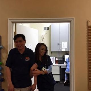 Two people standing in an office setting, one appearing to smile.