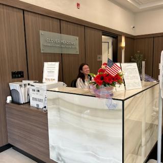 A welcoming reception area with a modern front desk and decorative flowers.