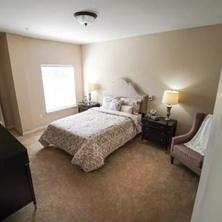 A cozy and well-furnished bedroom with a comfortable bed, nightstands, and lamps.