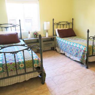 A cozy bedroom with two twin beds and a window letting in natural light.