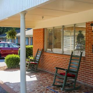 A cozy porch setup with rocking chairs inviting relaxation in a sunny residential area.