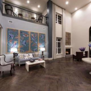 A spacious and modern living room with high ceilings, featuring contemporary artwork and elegant furniture.