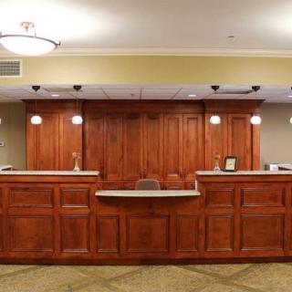 A hotel reception desk with wooden paneling and ambient lighting.