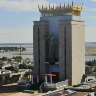 A large, iconic building with a prominent statue and unique architectural design.