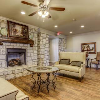 A cozy living room with a stone fireplace and comfortable seating.