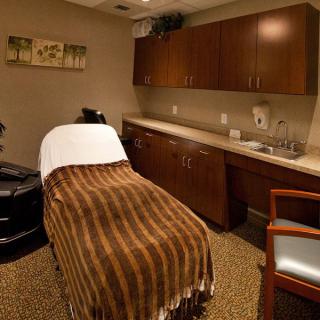 A cozy spa treatment room with a massage table and warm lighting.