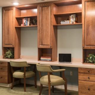 A well-organized home office setup with wooden cabinets, a desk area, and comfortable chairs.