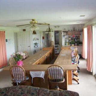 Spacious kitchen with a long dining table and multiple chairs.