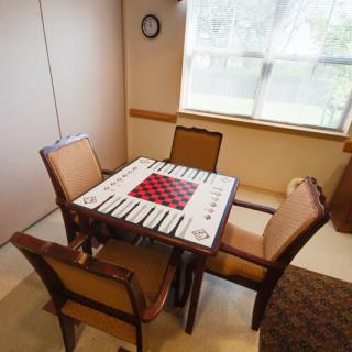 A cozy indoor room with a table and chairs set up for a game.