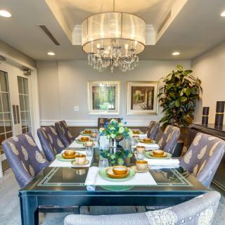 An elegantly decorated dining room with a large chandelier and sophisticated table setting.