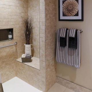 A modern bathroom with tiled walls, neatly arranged towels, and decorative elements.
