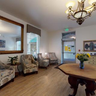 A welcoming lobby featuring elegant seating, a beautiful chandelier, and decorative elements.
