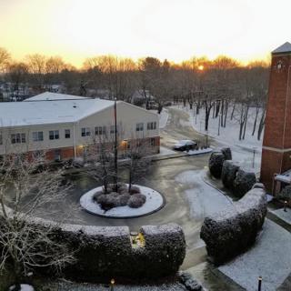 A serene winter morning with snow covering the ground as the sun rises.